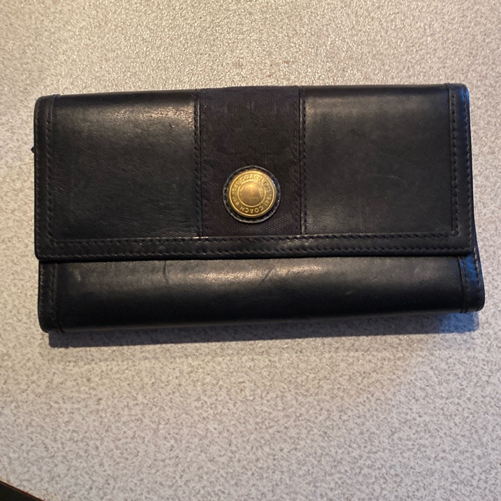 A black Coach leather trifold wallet